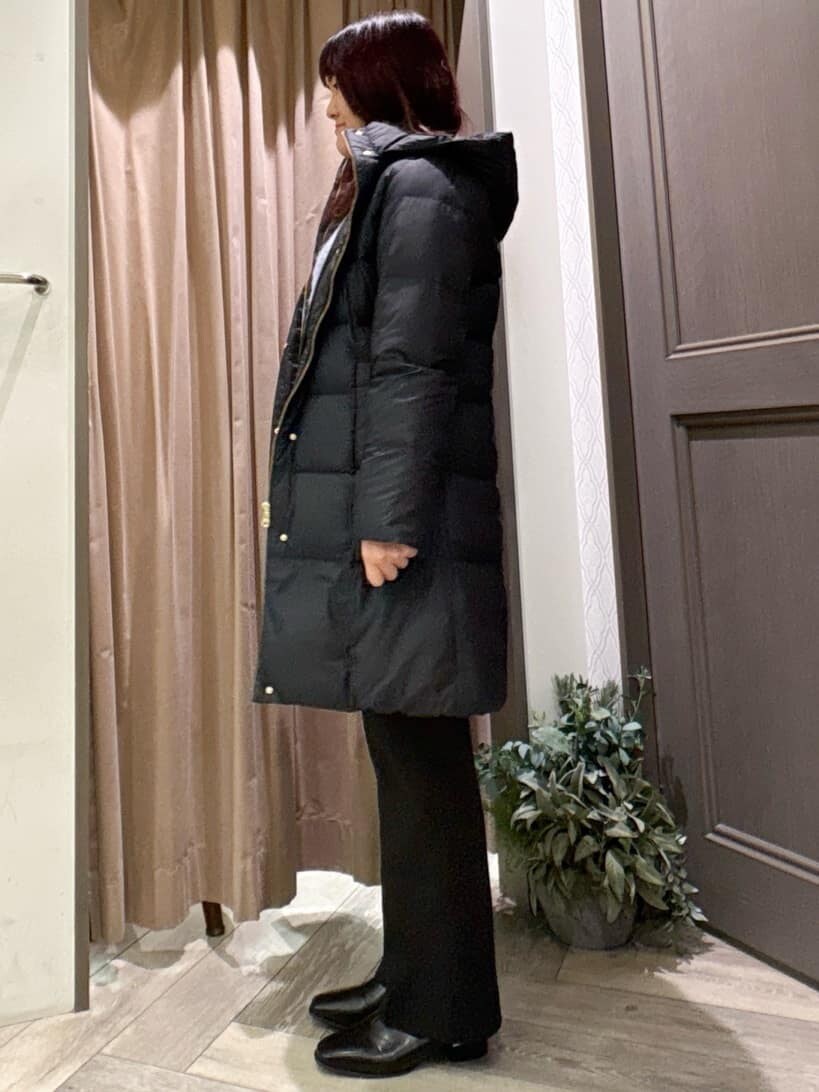 ブラック系のダウンジャケット/コート、ブルー系のニット/セーター、ブラック系のその他パンツを着用したレディースの秋コーディネートの2枚目の写真