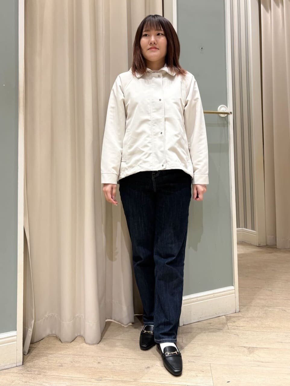ホワイト系のブルゾン、ピンク系のニット/セーター、ブルー系のデニムパンツを着用したレディースの冬コーディネートの4枚目の写真