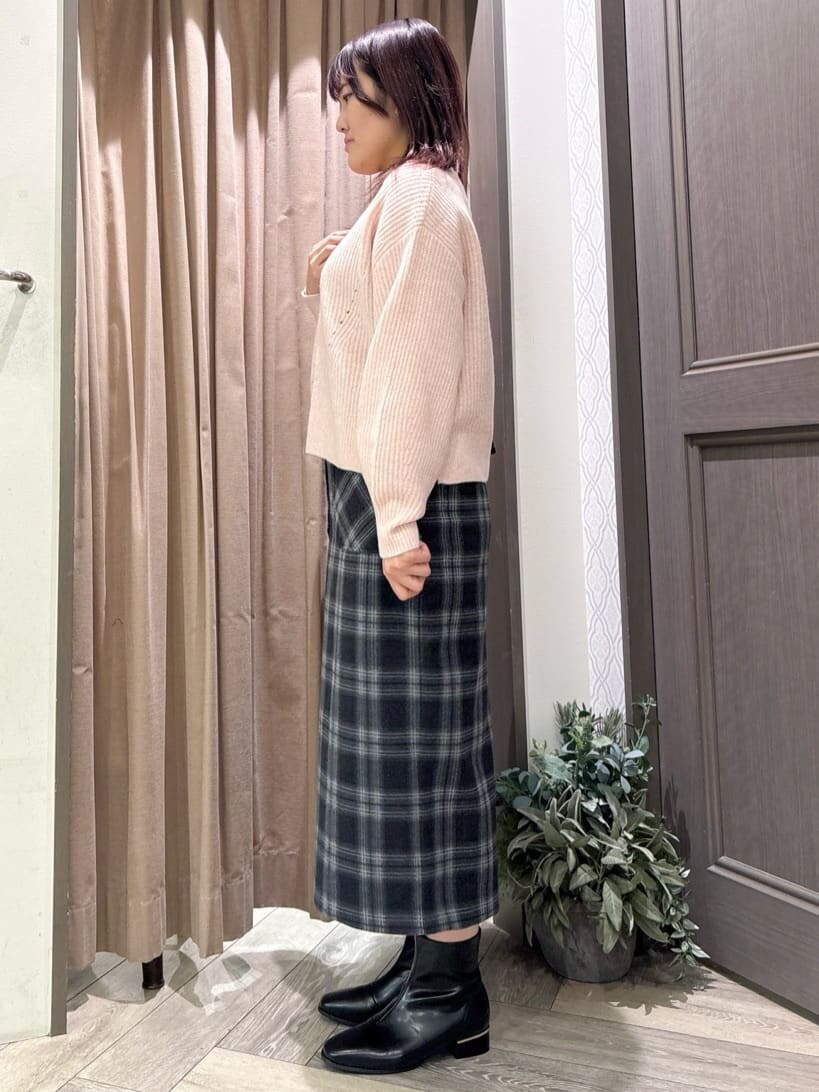 ピンク系のニット/セーター、ブルー系のスカート、ブラック系のショルダーバッグを着用したレディースの冬コーディネートの2枚目の写真