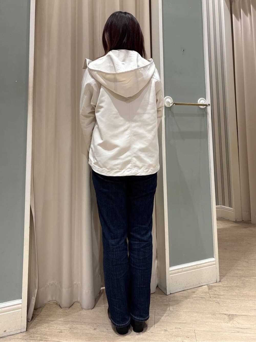 ホワイト系のブルゾン、ピンク系のニット/セーター、ブルー系のデニムパンツを着用したレディースの冬コーディネートの3枚目の写真
