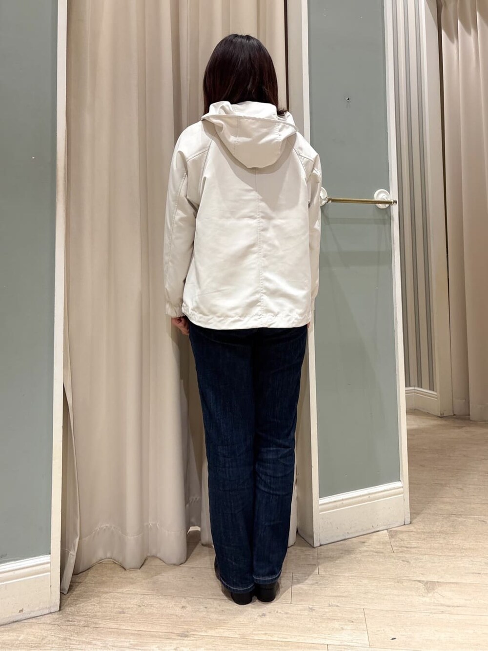 ホワイト系のブルゾン、ピンク系のニット/セーター、ブルー系のデニムパンツを着用したレディースの冬コーディネートの6枚目の写真