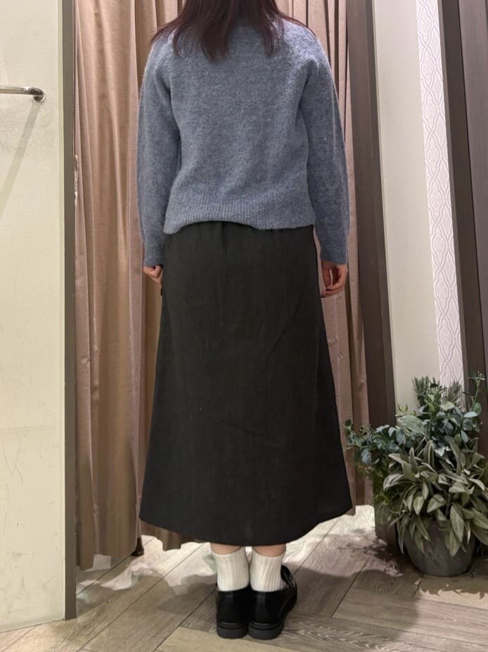 ブルー系のニット/セーター、ブラック系のスカート、グレー系のショルダーバッグを着用したレディースの秋コーディネートの5枚目の写真