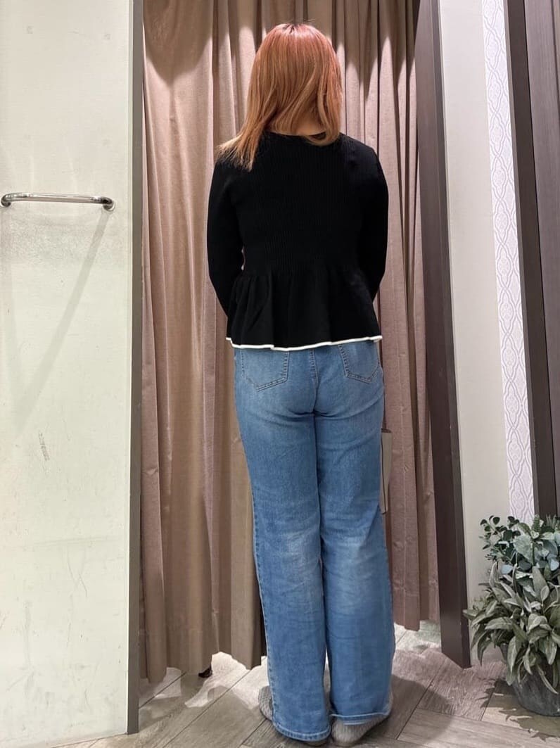 ブラック系のニット/セーター、ブルー系のデニムパンツ、グレー系のトートバッグを着用したレディースの春コーディネートの3枚目の写真