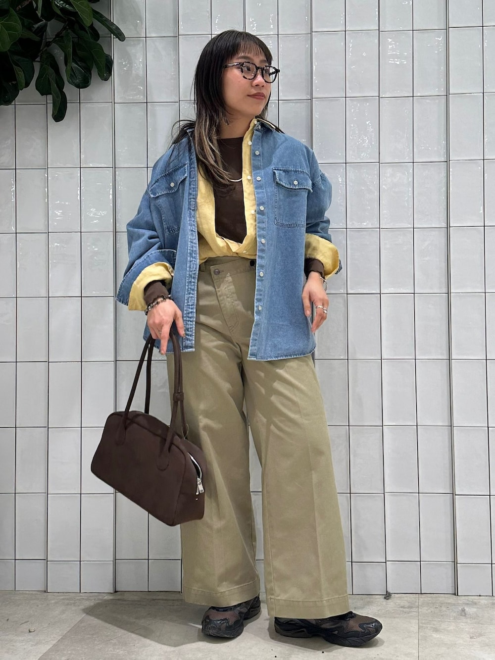 ベージュ系のチノパンツ、ブルー系のシャツ/ブラウス、イエロー系のシャツ/ブラウスを着用したレディースの春コーディネートの2枚目の写真