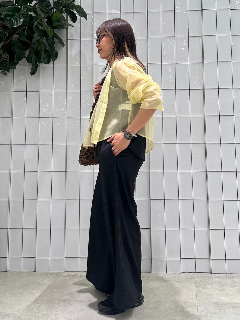 イエロー系のブルゾン、ブラック系のその他パンツ、ブラウン系のトートバッグを着用したレディースの春コーディネートの4枚目の写真