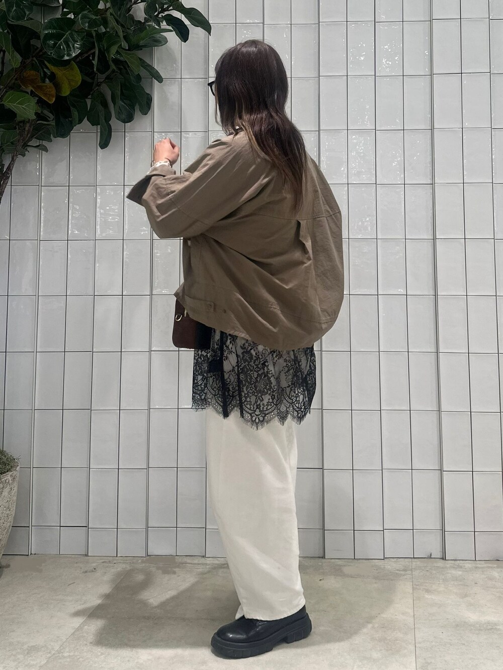 ホワイト系のデニムパンツ、グリーン系のシャツ/ブラウス、ブラック系のキャミソールを着用したレディースの春コーディネートの3枚目の写真