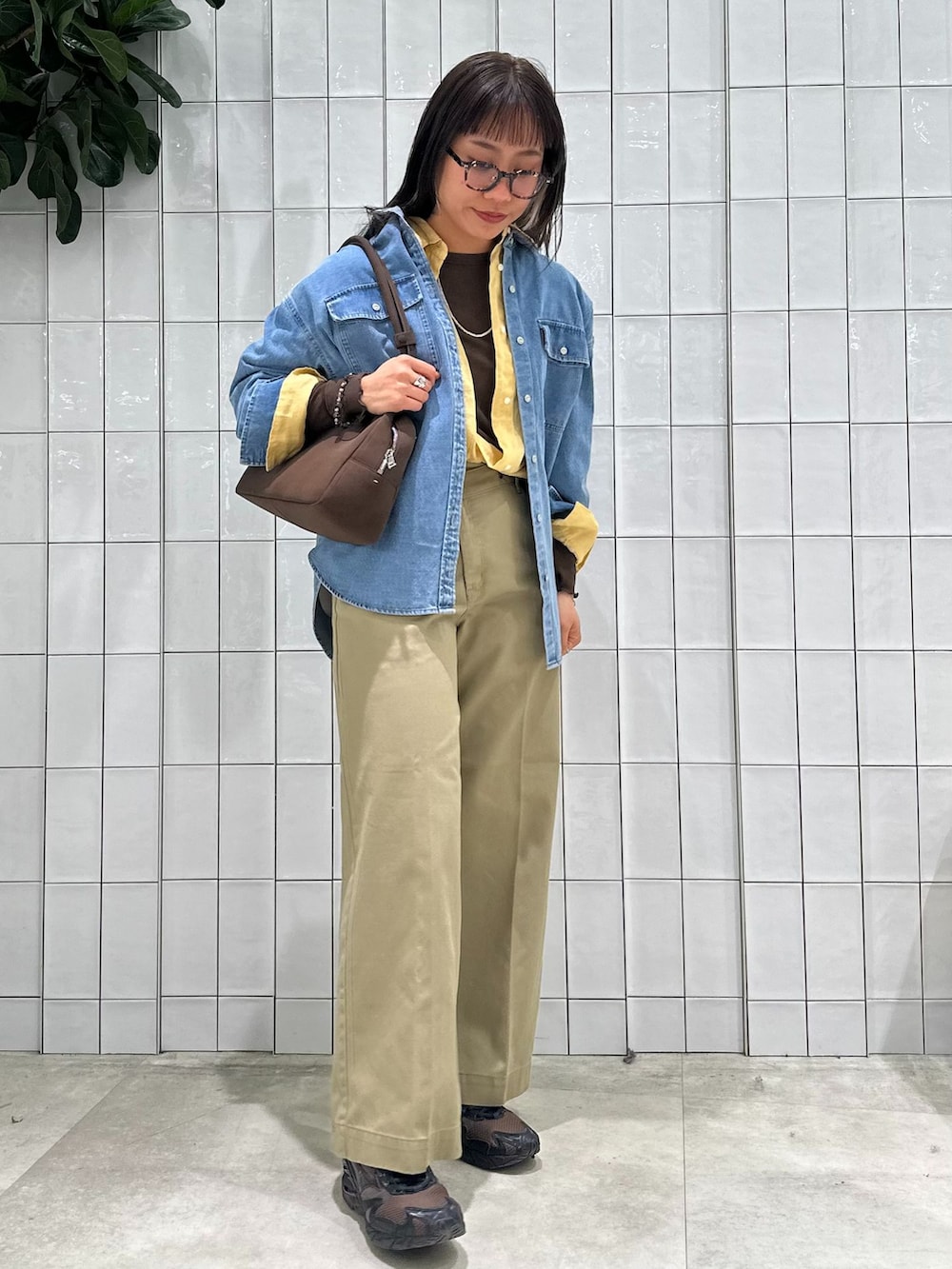 ベージュ系のチノパンツ、ブルー系のシャツ/ブラウス、イエロー系のシャツ/ブラウスを着用したレディースの春コーディネートの6枚目の写真