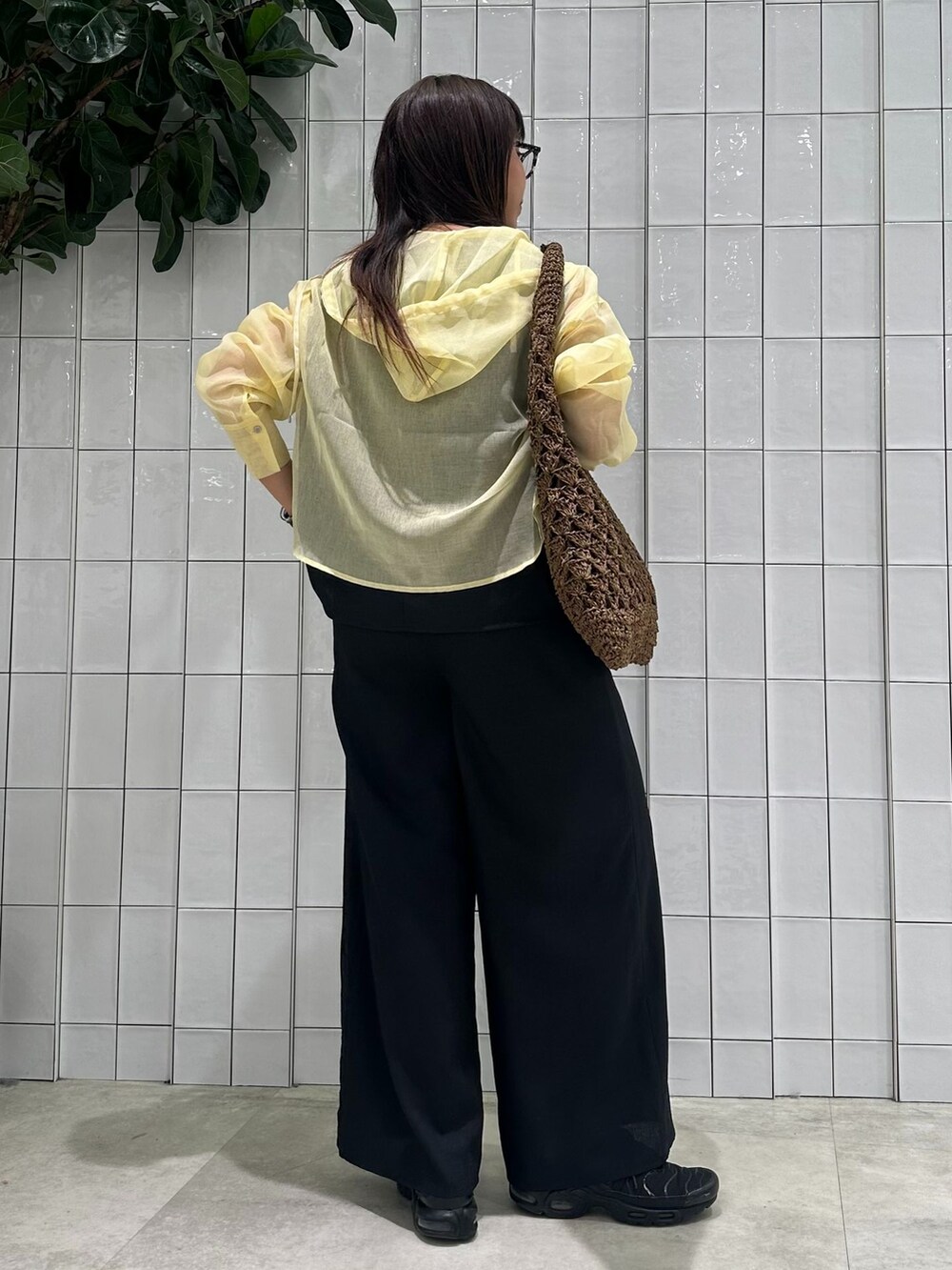 イエロー系のブルゾン、ブラック系のその他パンツ、ブラウン系のトートバッグを着用したレディースの春コーディネートの5枚目の写真