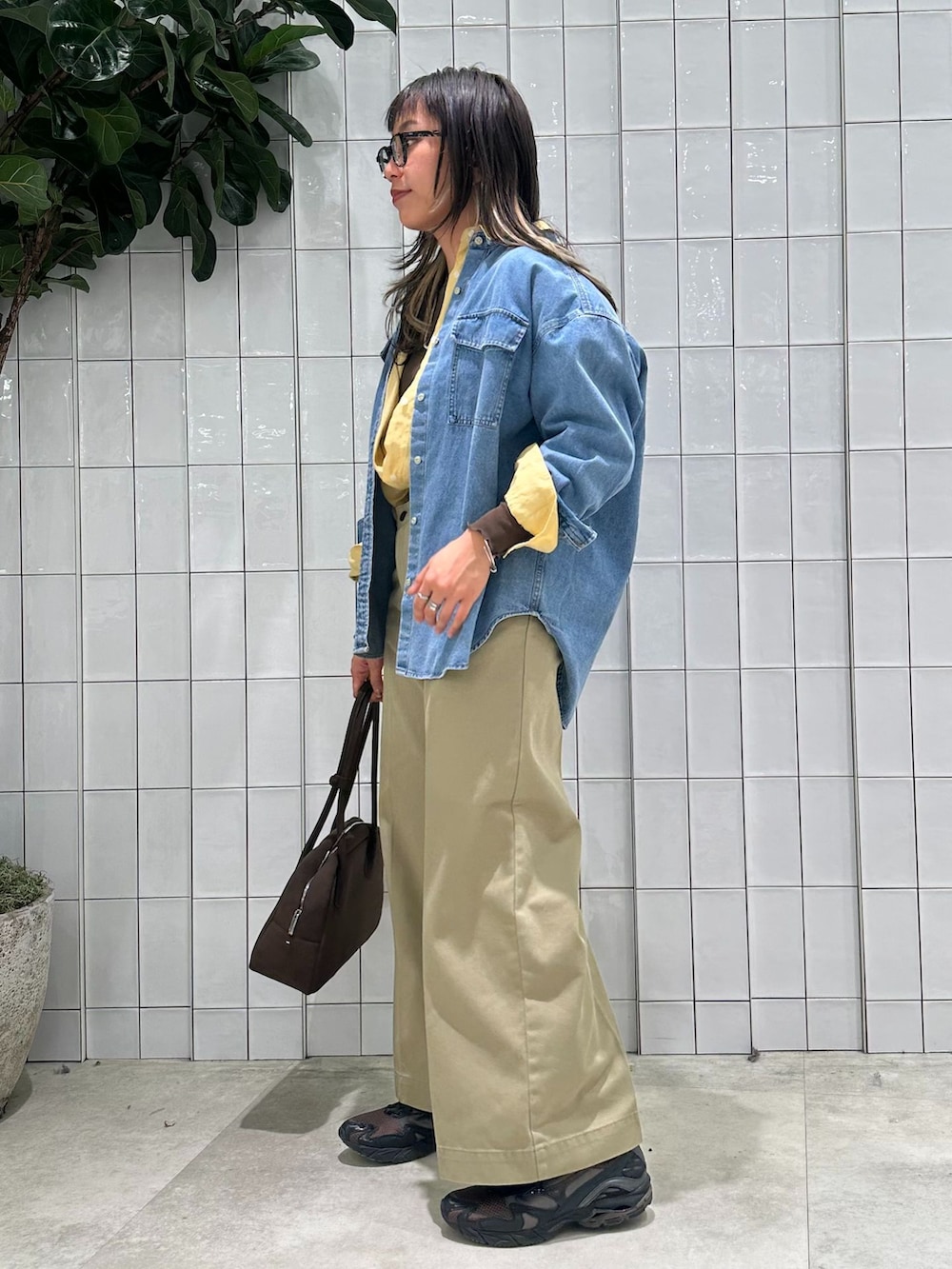 ベージュ系のチノパンツ、ブルー系のシャツ/ブラウス、イエロー系のシャツ/ブラウスを着用したレディースの春コーディネートの3枚目の写真