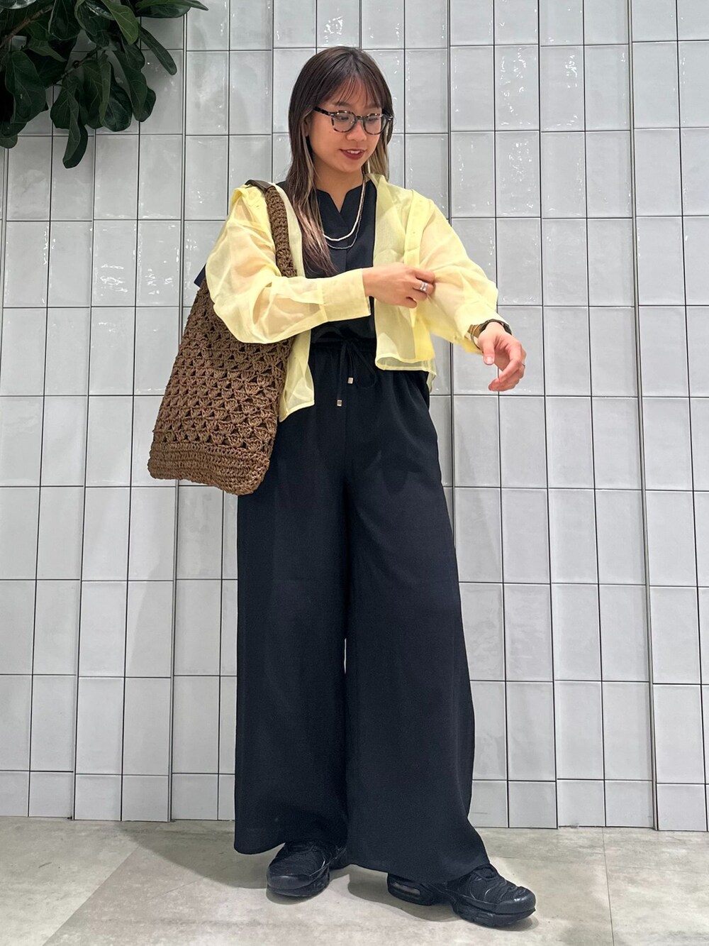 イエロー系のブルゾン、ブラック系のその他パンツ、ブラウン系のトートバッグを着用したレディースの春コーディネートの3枚目の写真