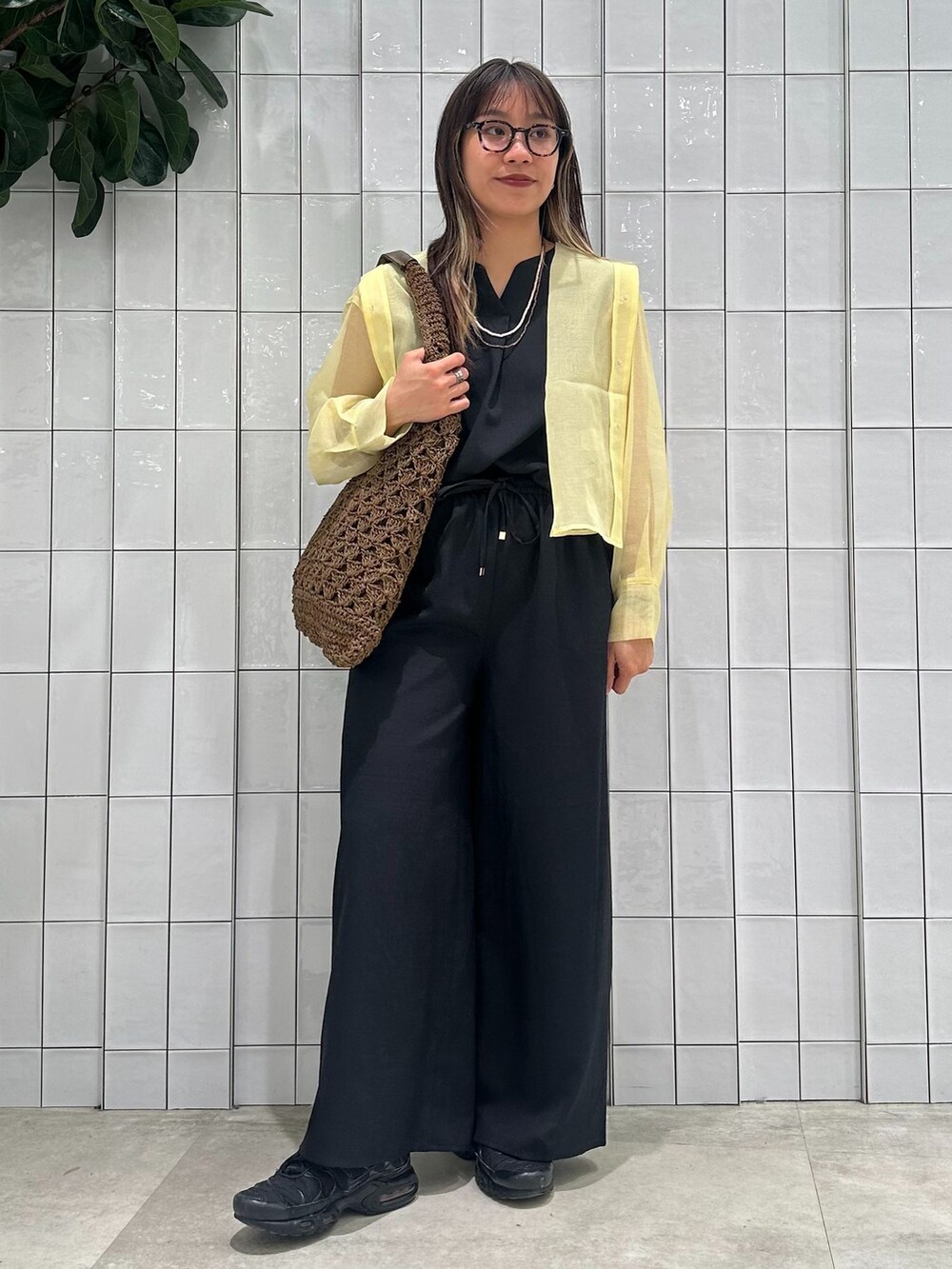 イエロー系のブルゾン、ブラック系のその他パンツ、ブラウン系のトートバッグを着用したレディースの春コーディネートの8枚目の写真