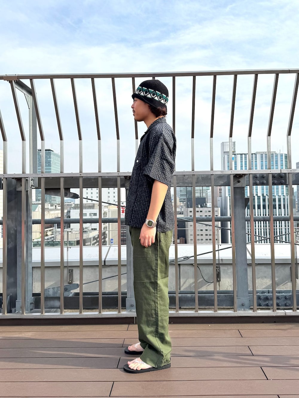 グリーン系のカーゴパンツ、ブルー系のシャツ/ブラウス、ホワイト系のサンダルを着用したメンズの春コーディネートの2枚目の写真
