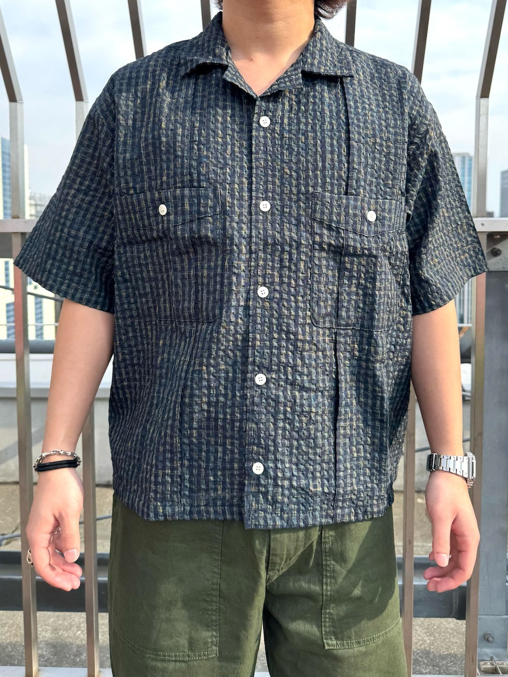 グリーン系のカーゴパンツ、ブルー系のシャツ/ブラウス、ホワイト系のサンダルを着用したメンズの春コーディネートの3枚目の写真