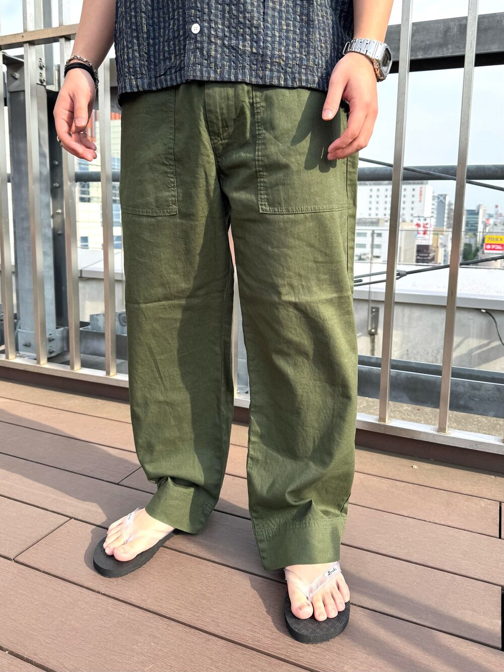 グリーン系のカーゴパンツ、ブルー系のシャツ/ブラウス、ホワイト系のサンダルを着用したメンズの春コーディネートの4枚目の写真