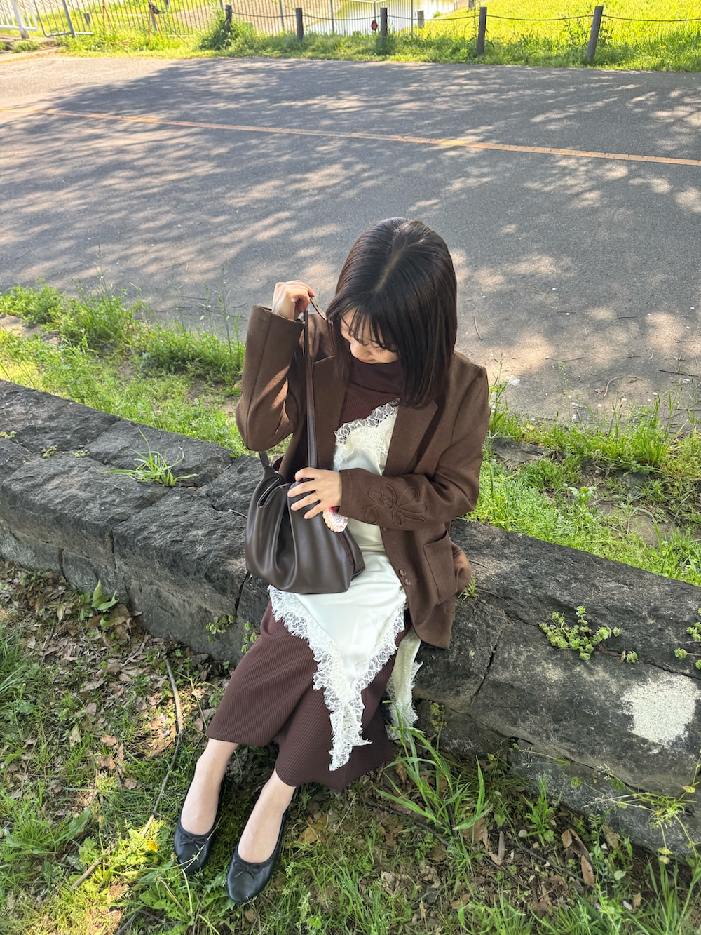 ブラウン系のショルダーバッグ、ブラウン系のジャケット/アウター、ブラウン系のワンピースを着用したレディースの春コーディネートの3枚目の写真
