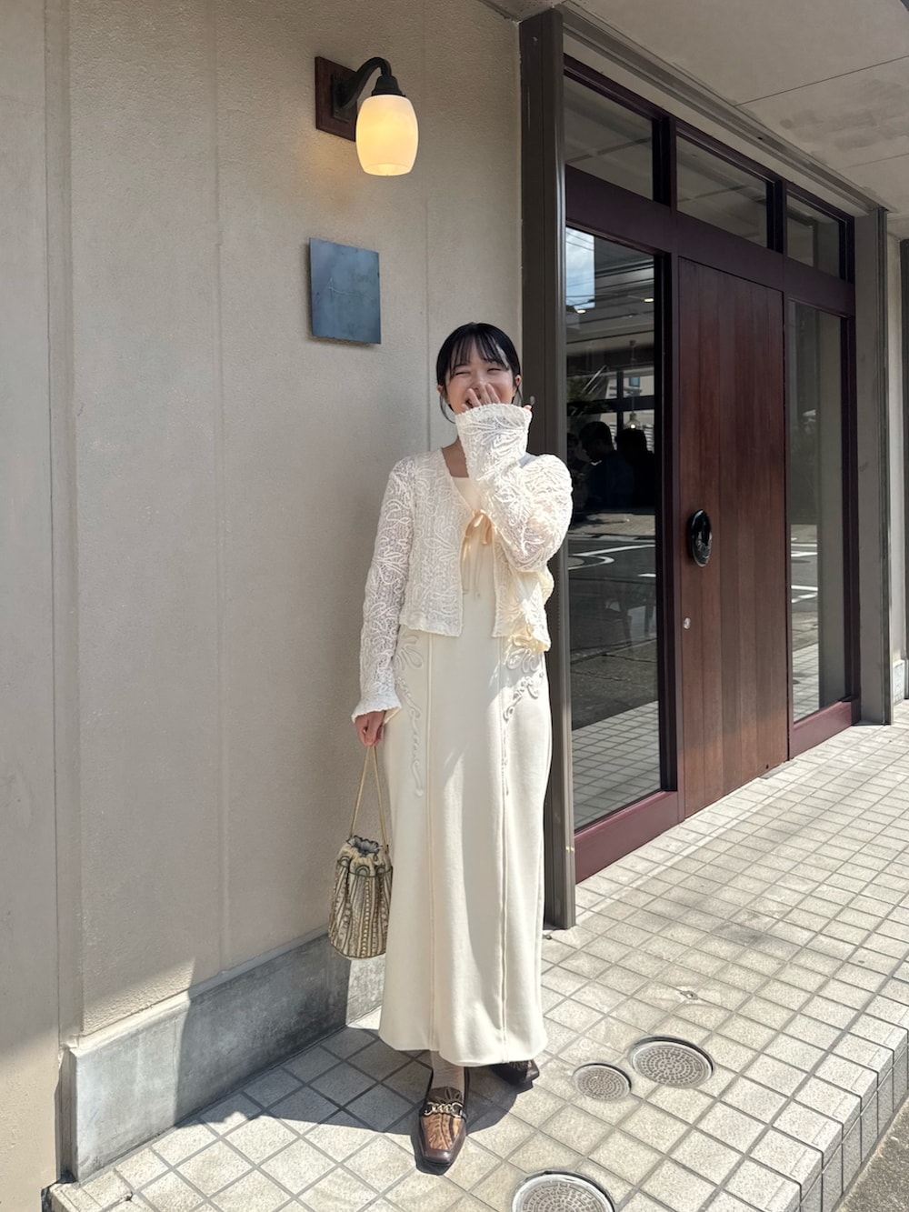 ゴールド系のバッグ、ホワイト系のカーディガン/ボレロ、ホワイト系のワンピースを着用したレディースの秋コーディネートの2枚目の写真
