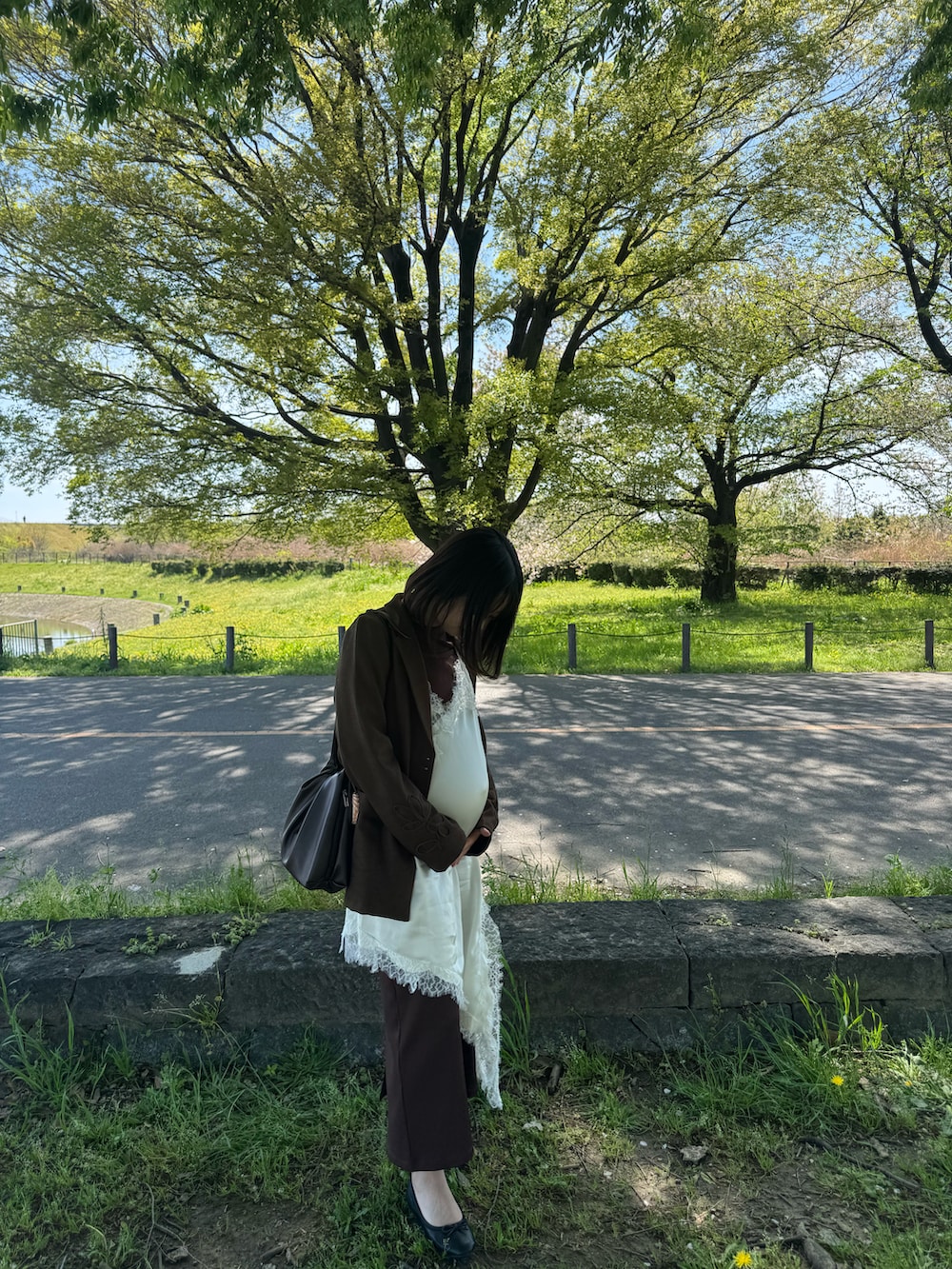 ブラウン系のショルダーバッグ、ブラウン系のジャケット/アウター、ブラウン系のワンピースを着用したレディースの春コーディネートの2枚目の写真