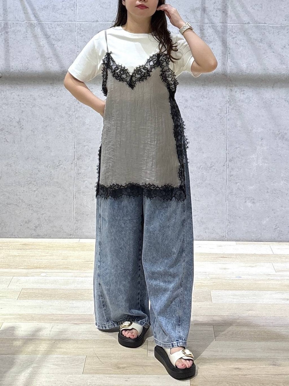 ブルー系のデニムパンツ、ホワイト系のサンダル、ホワイト系のTシャツ/カットソーを着用したレディースの夏コーディネートの3枚目の写真