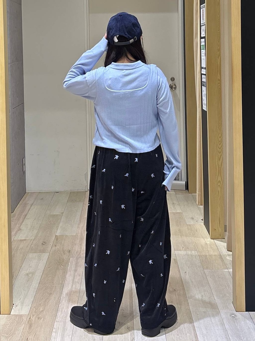 ブルー系のニット/セーター、ブラック系のその他パンツ、ブラック系のブーツを着用したレディースの秋コーディネートの5枚目の写真