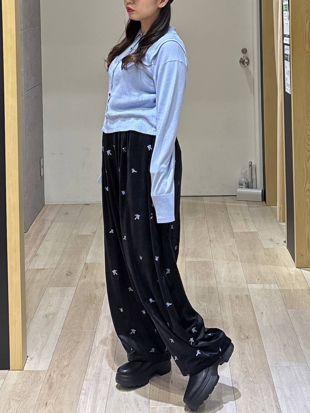ブルー系のニット/セーター、ブラック系のその他パンツ、ブラック系のブーツを着用したレディースの秋コーディネートの2枚目の写真