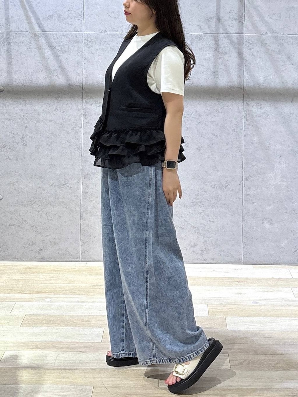 ブルー系のデニムパンツ、ホワイト系のサンダル、ホワイト系のTシャツ/カットソーを着用したレディースの春コーディネートの3枚目の写真