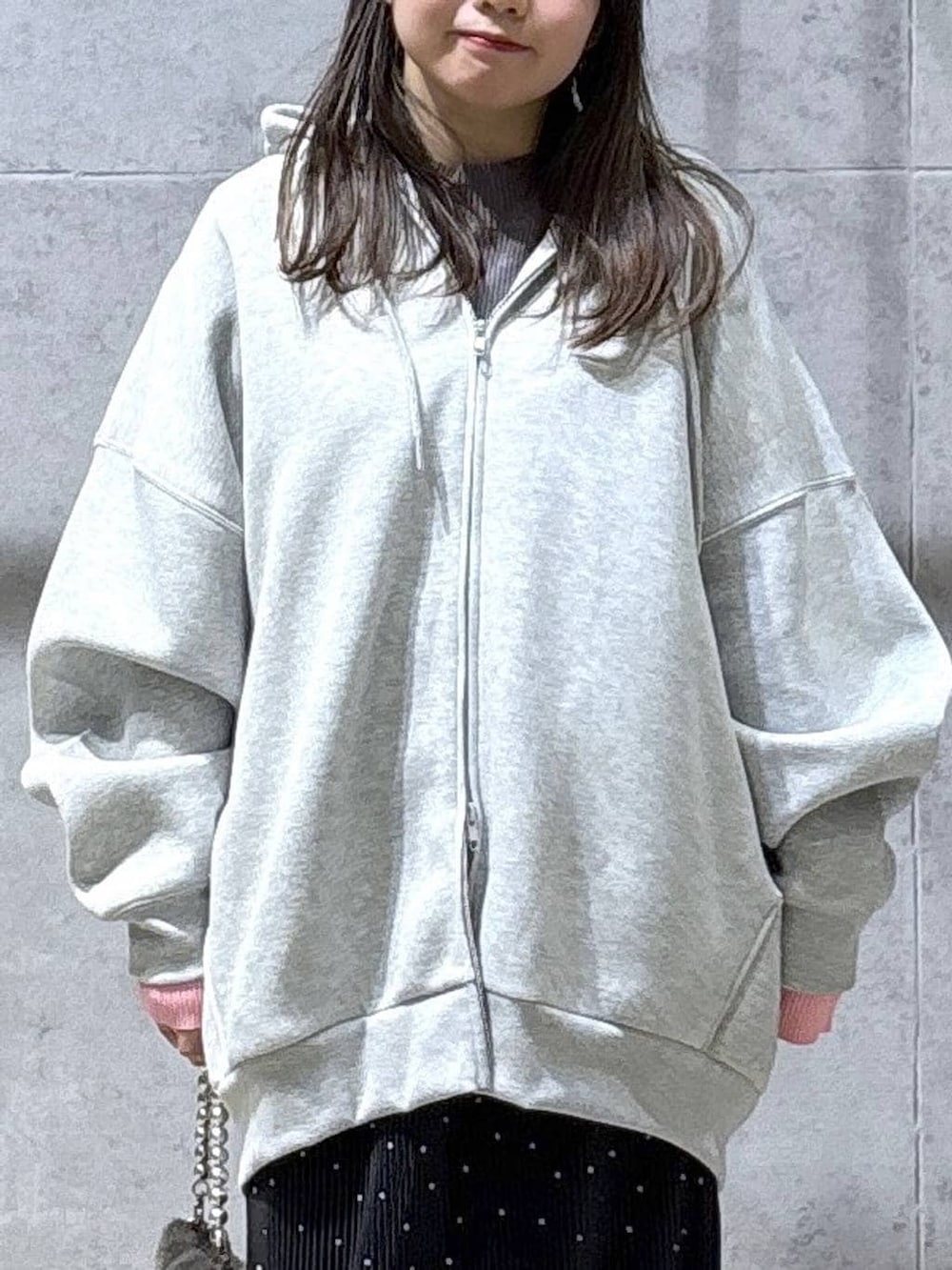 グレー系のニット/セーター、グレー系のパーカー、ブラック系のブーツを着用したレディースの冬コーディネートの5枚目の写真