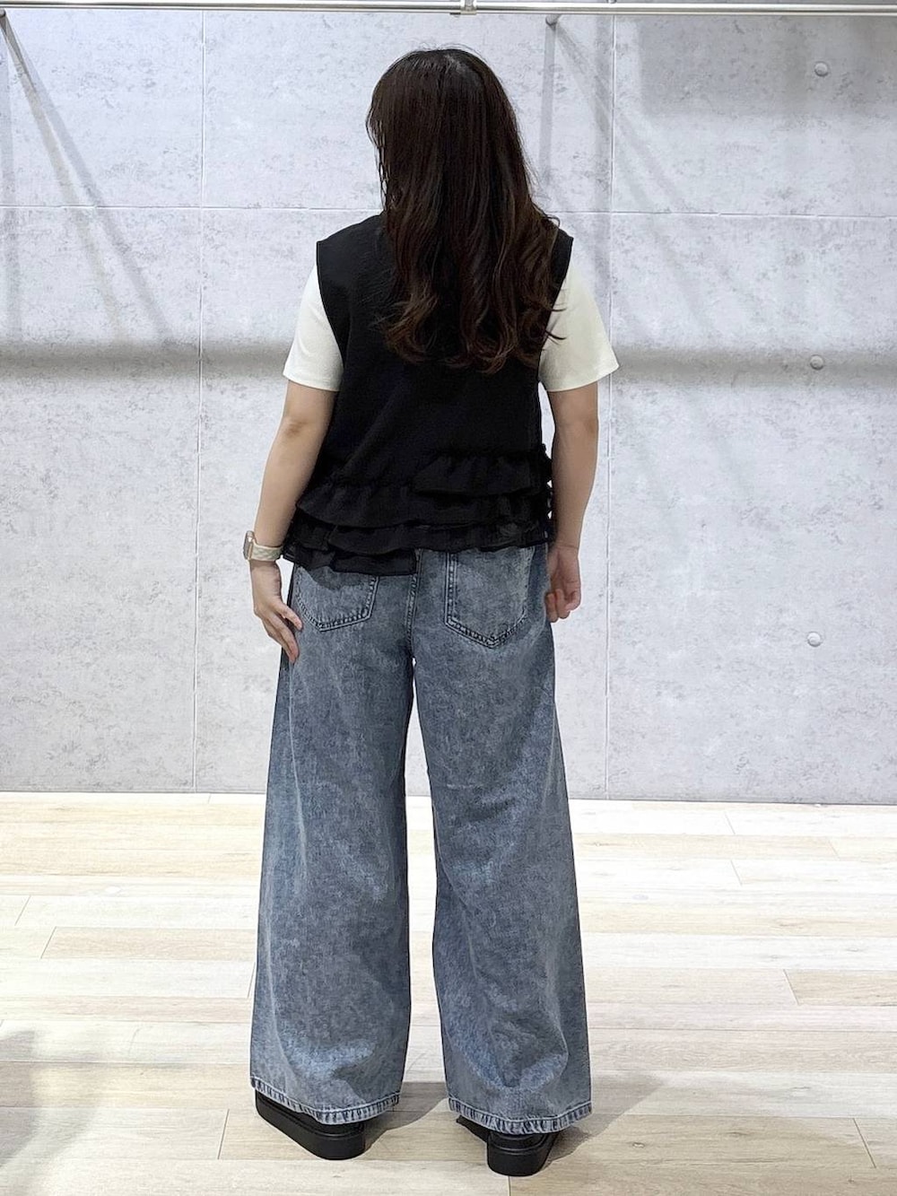 ブルー系のデニムパンツ、ホワイト系のサンダル、ホワイト系のTシャツ/カットソーを着用したレディースの春コーディネートの5枚目の写真