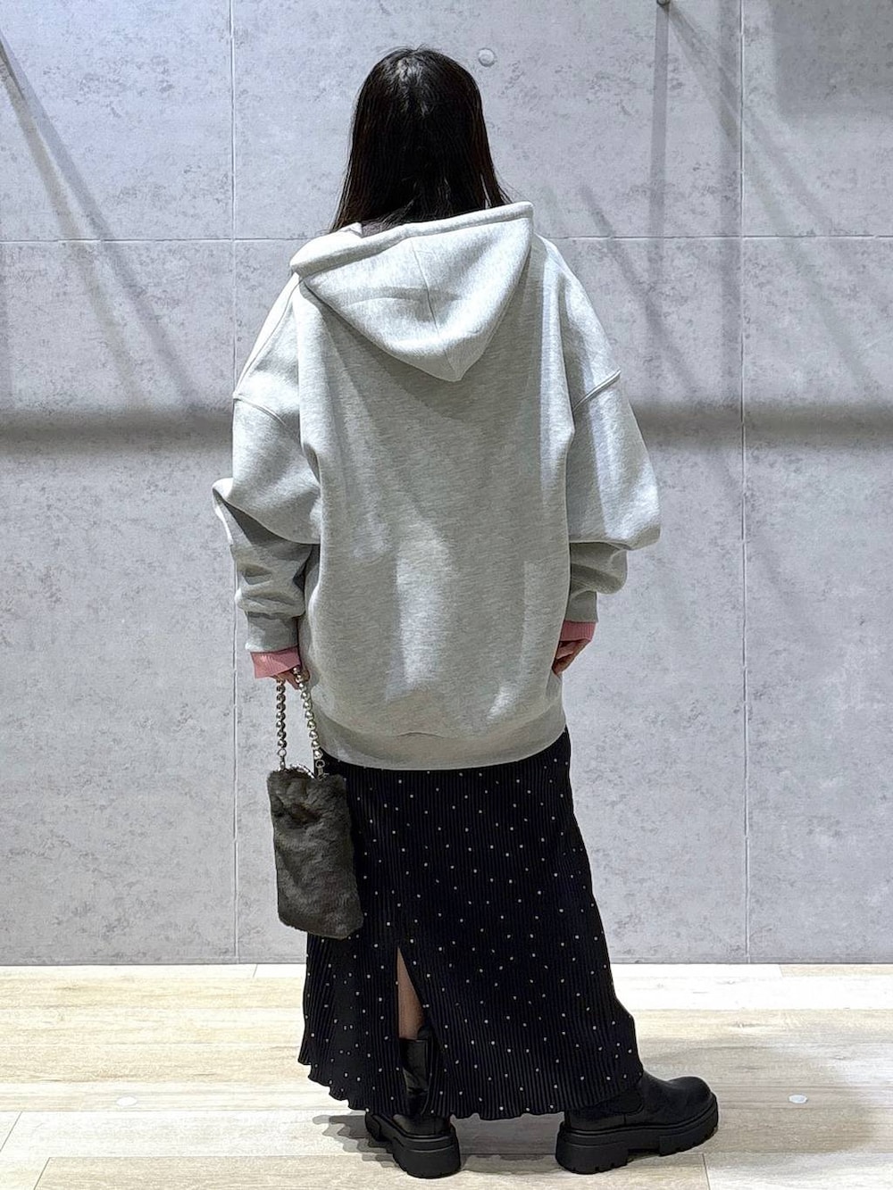 グレー系のニット/セーター、グレー系のパーカー、ブラック系のブーツを着用したレディースの冬コーディネートの4枚目の写真