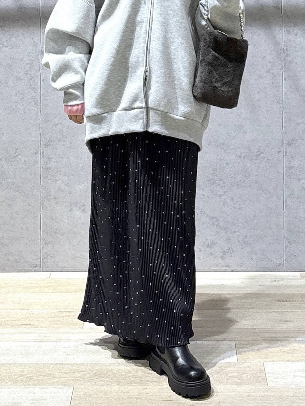 グレー系のニット/セーター、グレー系のパーカー、ブラック系のブーツを着用したレディースの冬コーディネートの6枚目の写真