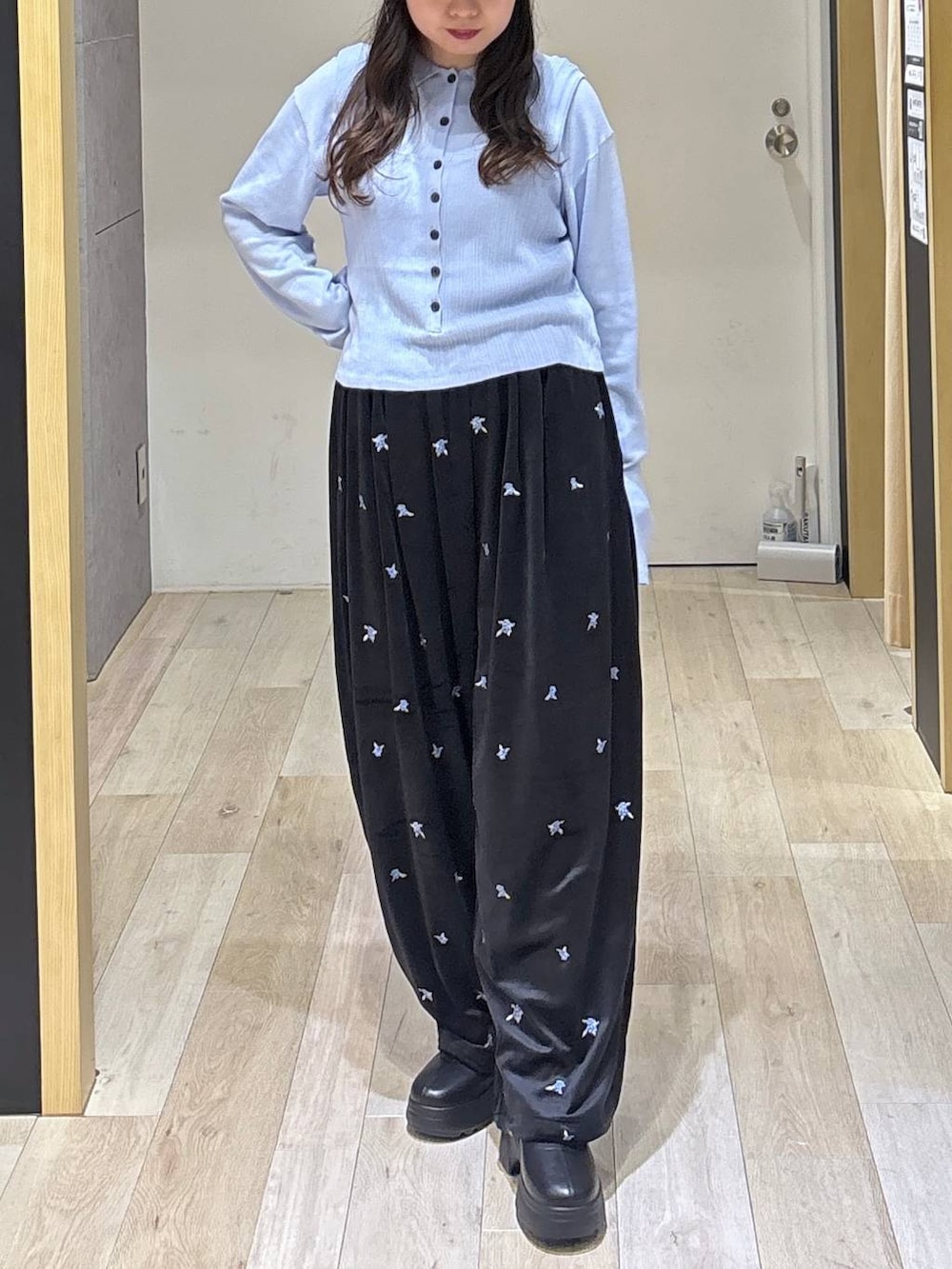 ブルー系のニット/セーター、ブラック系のその他パンツ、ブラック系のブーツを着用したレディースの秋コーディネートの3枚目の写真