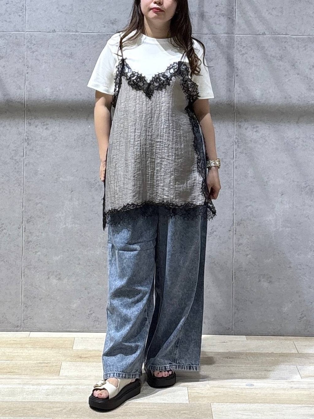 ブルー系のデニムパンツ、ホワイト系のサンダル、ホワイト系のTシャツ/カットソーを着用したレディースの夏コーディネートの4枚目の写真