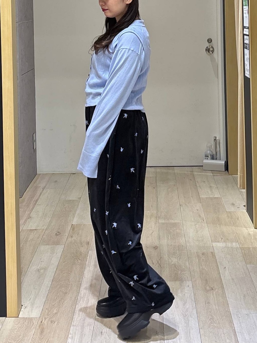 ブルー系のニット/セーター、ブラック系のその他パンツ、ブラック系のブーツを着用したレディースの秋コーディネートの4枚目の写真