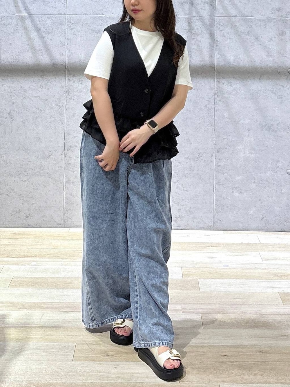 ブルー系のデニムパンツ、ホワイト系のサンダル、ホワイト系のTシャツ/カットソーを着用したレディースの春コーディネートの4枚目の写真