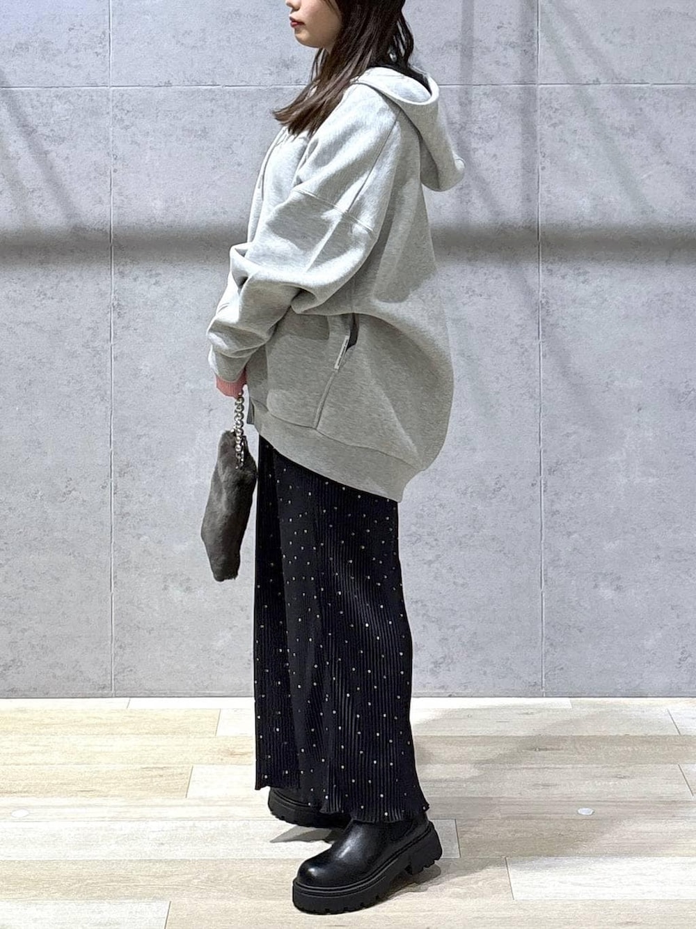 グレー系のニット/セーター、グレー系のパーカー、ブラック系のブーツを着用したレディースの冬コーディネートの3枚目の写真