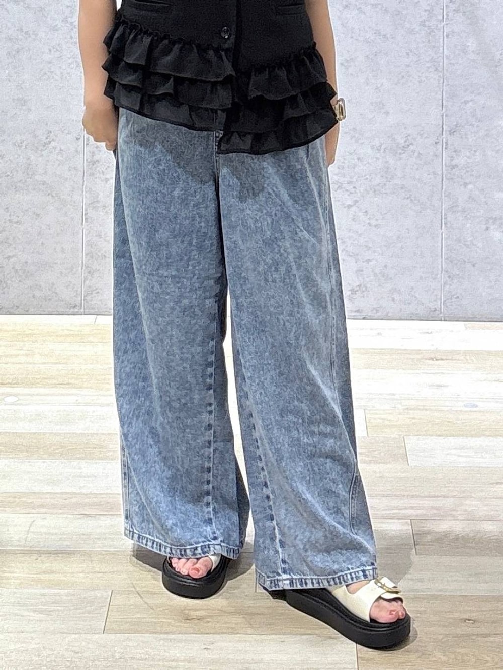 ブルー系のデニムパンツ、ホワイト系のサンダル、ホワイト系のTシャツ/カットソーを着用したレディースの春コーディネートの7枚目の写真