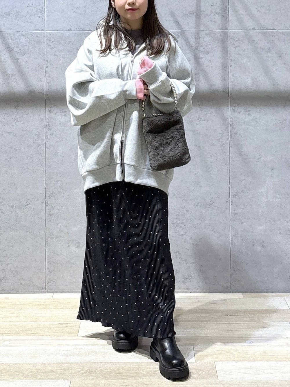 グレー系のニット/セーター、グレー系のパーカー、ブラック系のブーツを着用したレディースの冬コーディネートの2枚目の写真