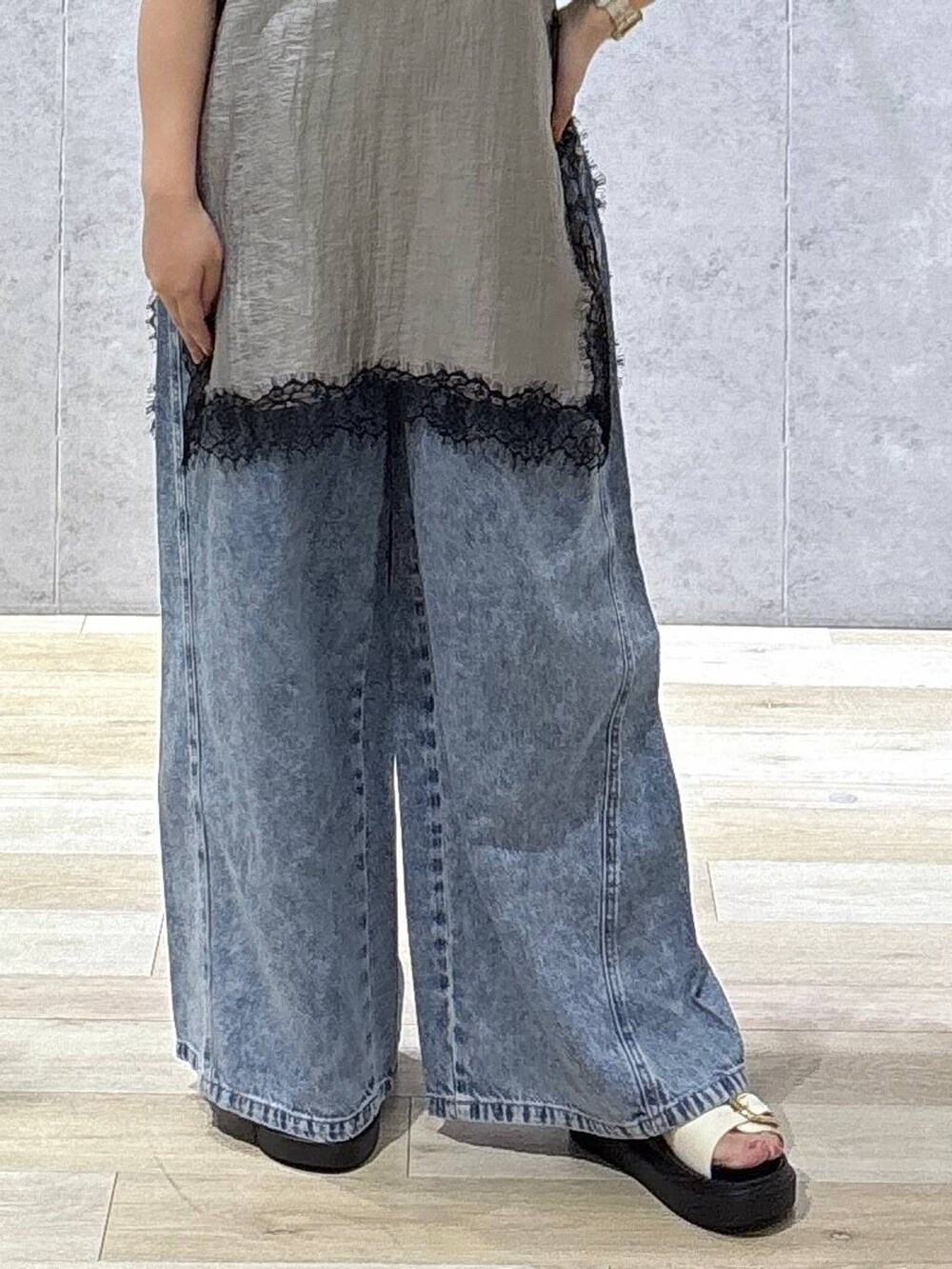 ブルー系のデニムパンツ、ホワイト系のサンダル、ホワイト系のTシャツ/カットソーを着用したレディースの夏コーディネートの7枚目の写真