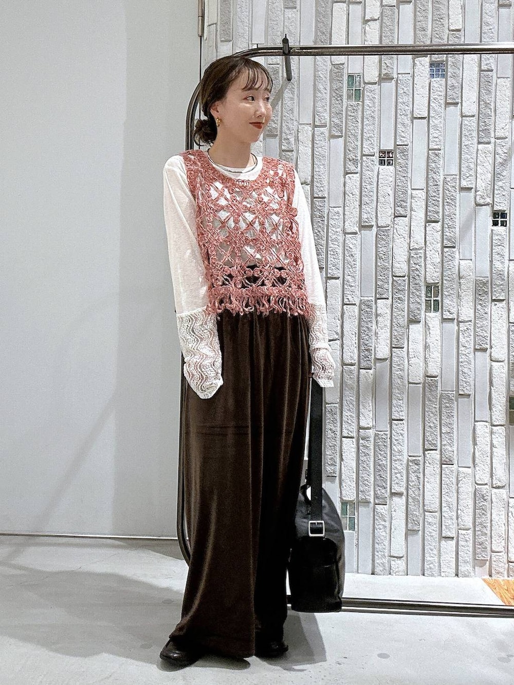 ピンク系のベスト、ブラック系のローファー、ホワイト系のTシャツ/カットソーを着用したレディースの秋コーディネートの2枚目の写真