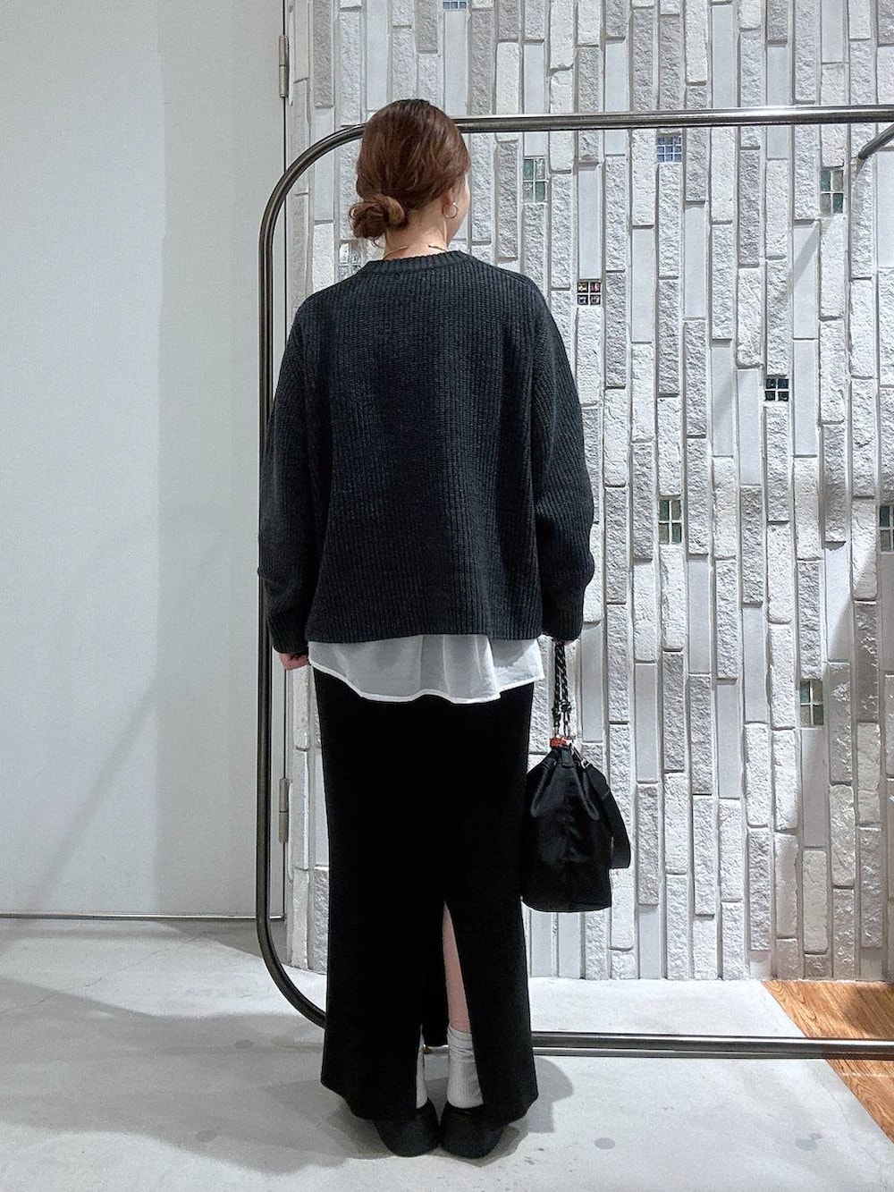 ブラック系のショルダーバッグ、ブラック系のスカート、ホワイト系のTシャツ/カットソーを着用したレディースの冬コーディネートの5枚目の写真