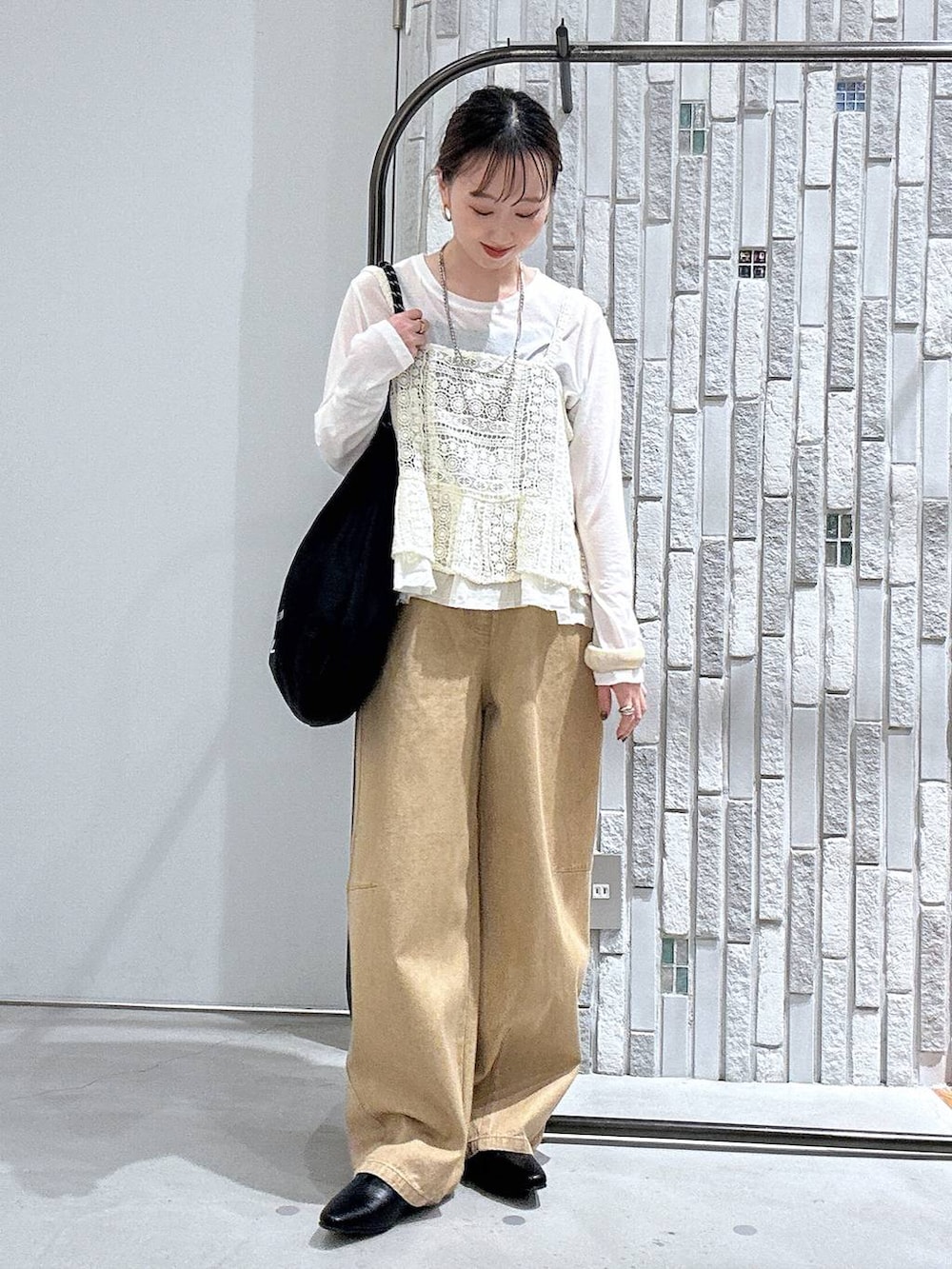 ホワイト系のTシャツ/カットソー、ベージュ系のその他パンツ、ブラック系のトートバッグを着用したレディースの春コーディネートの2枚目の写真