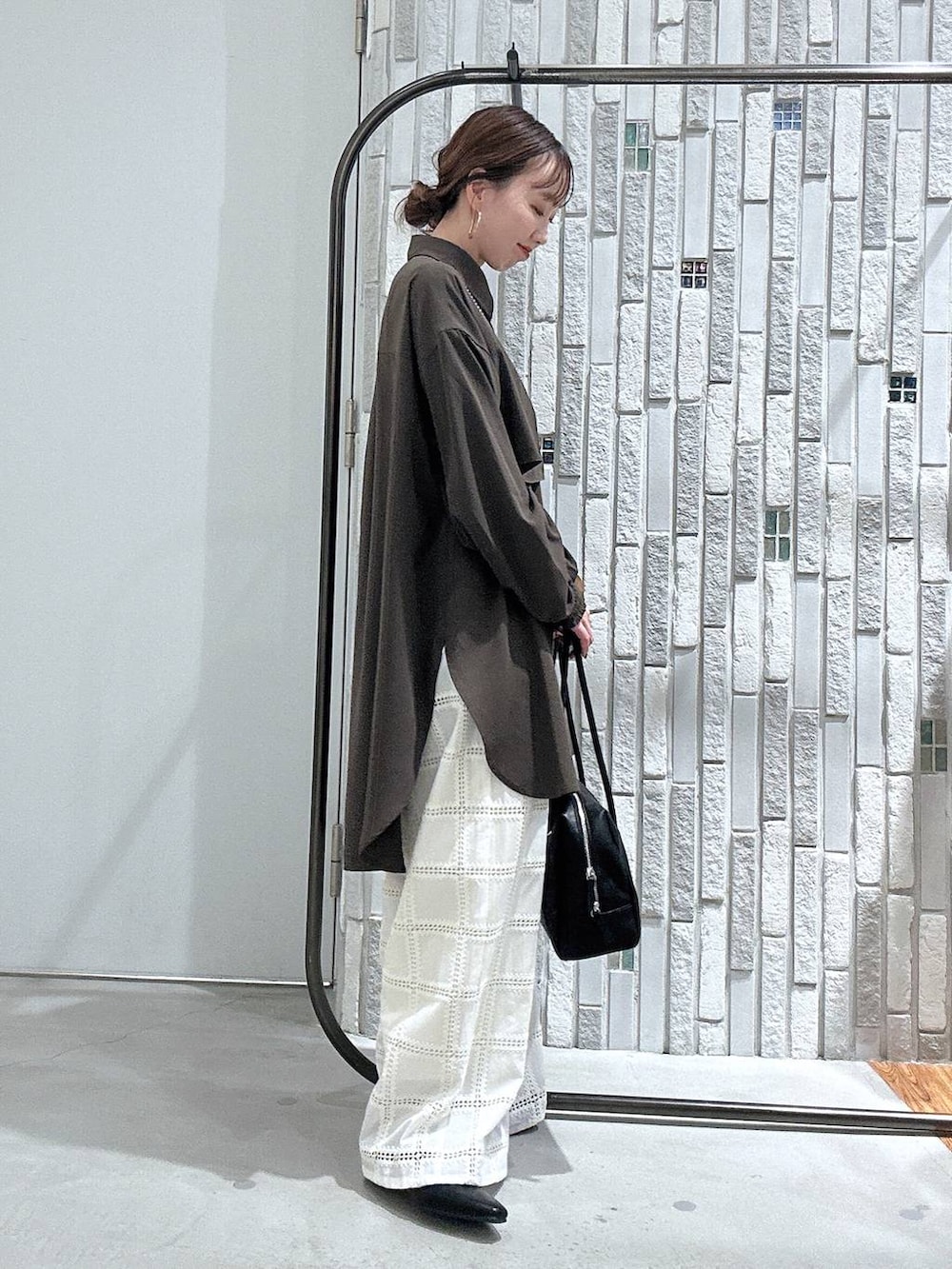 ブラウン系のシャツ/ブラウス、ブラック系のボストンバッグ、ホワイト系のその他パンツを着用したレディースの冬コーディネートの3枚目の写真