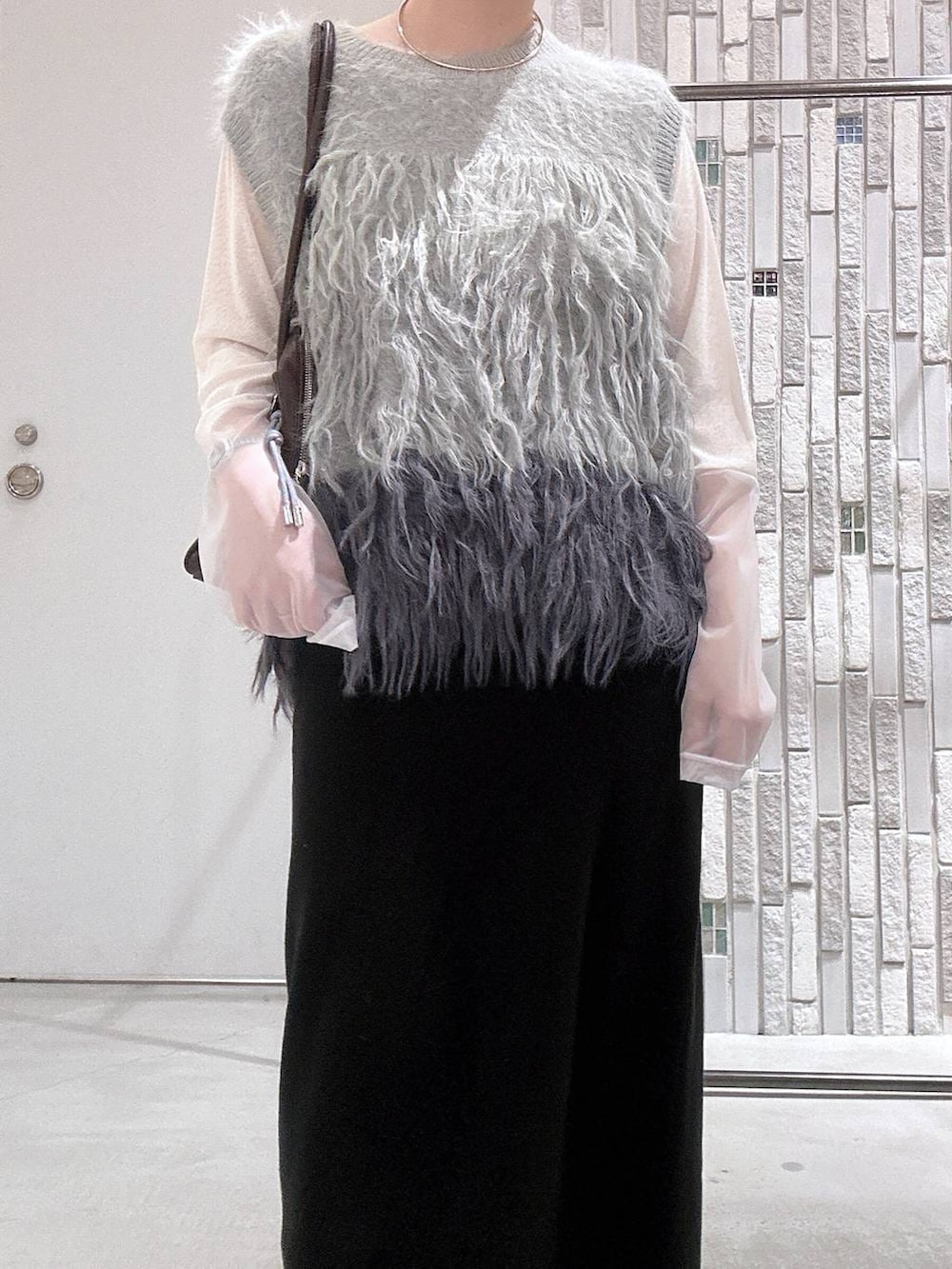 ホワイト系のTシャツ/カットソー、ブラック系のスカート、ブラック系のブーツを着用したレディースの冬コーディネートの5枚目の写真