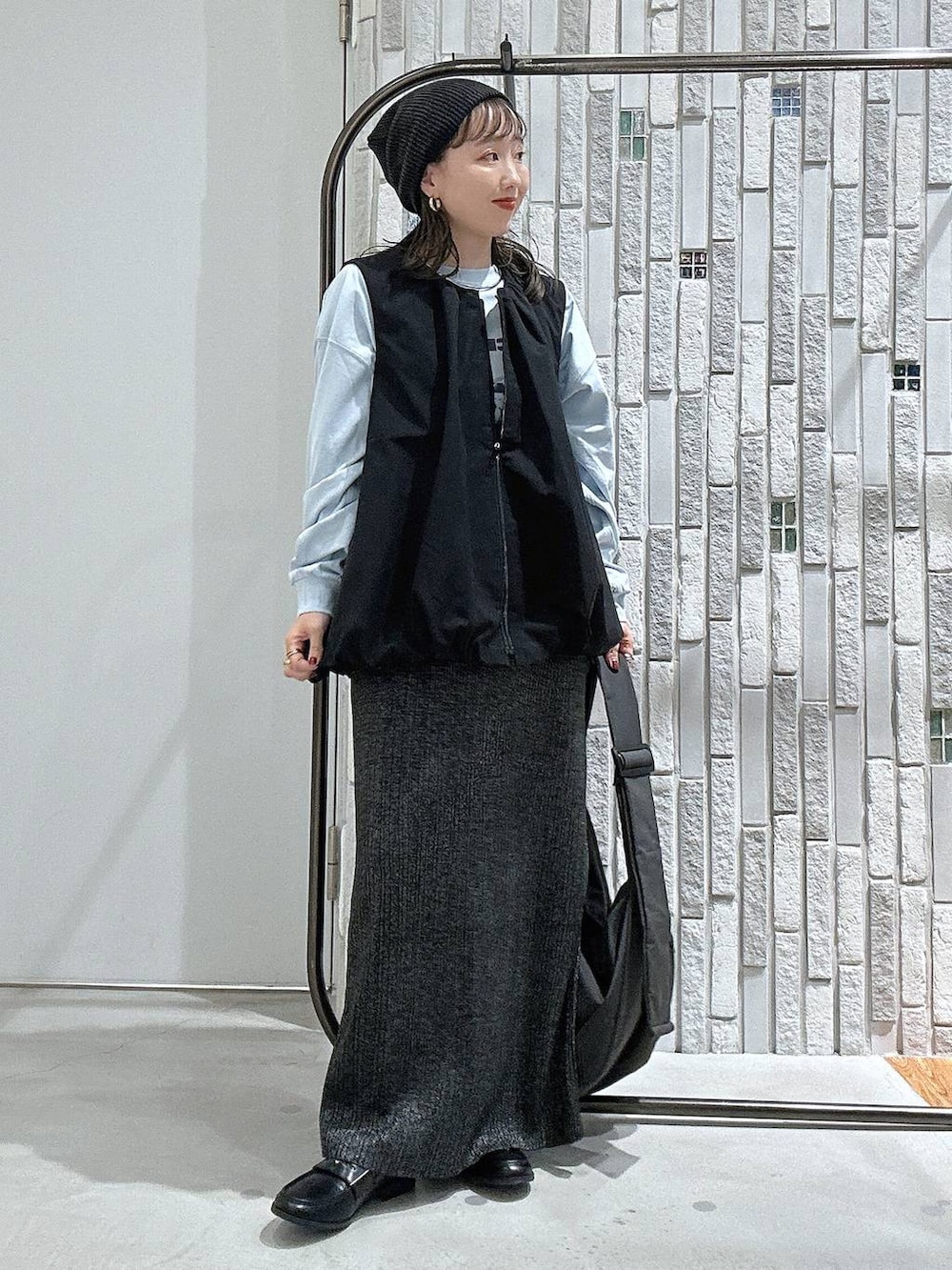 ブルー系のTシャツ/カットソー、グレー系のショルダーバッグ、ブラック系のベストを着用したレディースの秋コーディネートの2枚目の写真