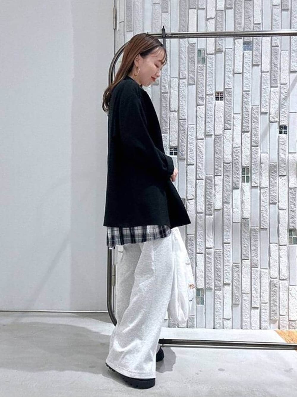 ホワイト系のTシャツ/カットソー、グレー系のスウェットパンツ、ブラック系のその他シューズを着用したレディースの春コーディネートの3枚目の写真