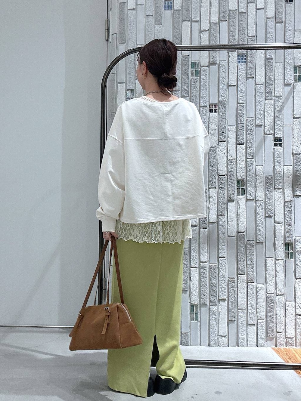 グリーン系のスカート、ブラック系のサンダル、イエロー系のボストンバッグを着用したレディースの春コーディネートの4枚目の写真