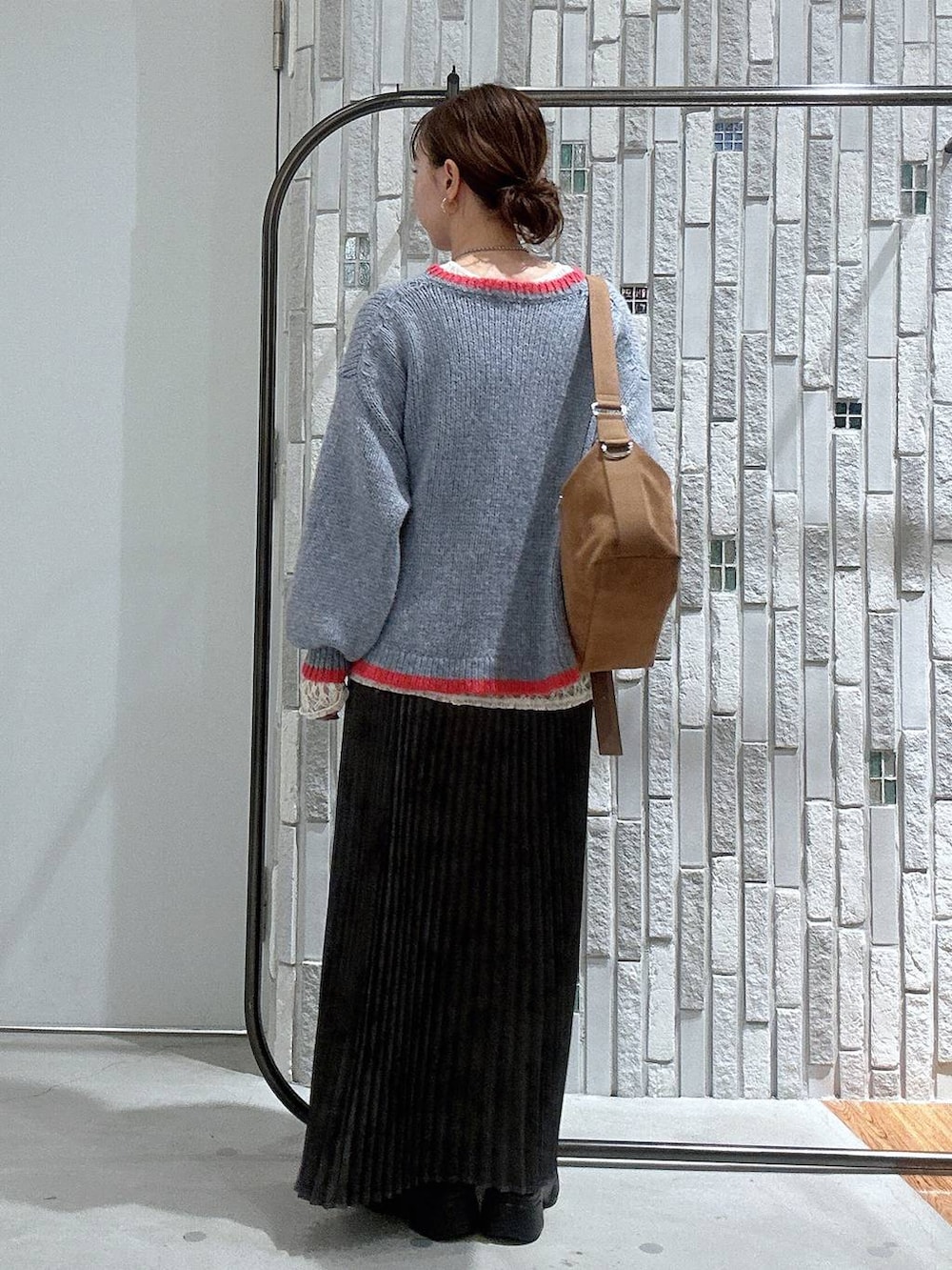 ブラウン系のショルダーバッグ、グレー系のスカート、ブラック系のブーツを着用したレディースの冬コーディネートの4枚目の写真