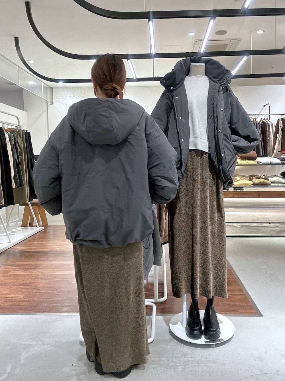 グレー系のその他アウター、ブラック系のブーツ、ホワイト系のTシャツ/カットソーを着用したレディースの冬コーディネートの4枚目の写真