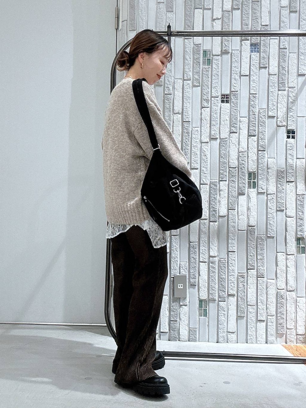 ホワイト系のTシャツ/カットソー、ベージュ系のニット/セーター、ブラック系のブーツを着用したレディースの冬コーディネートの3枚目の写真