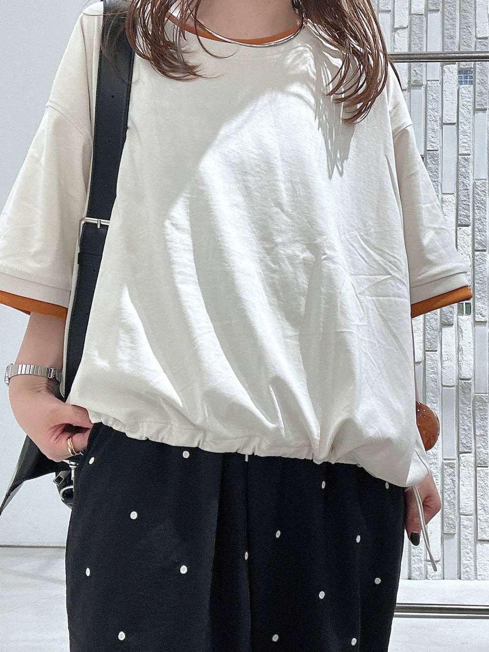 ベージュ系のTシャツ/カットソー、ブラック系のショルダーバッグ、ブラック系のその他パンツを着用したレディースの夏コーディネートの5枚目の写真