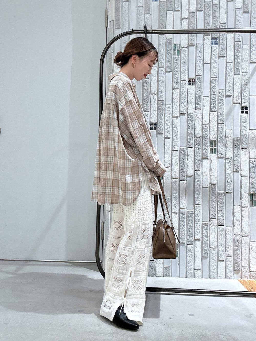 ブラウン系のボストンバッグ、ホワイト系のその他パンツ、ブラック系のパンプスを着用したレディースの春コーディネートの4枚目の写真